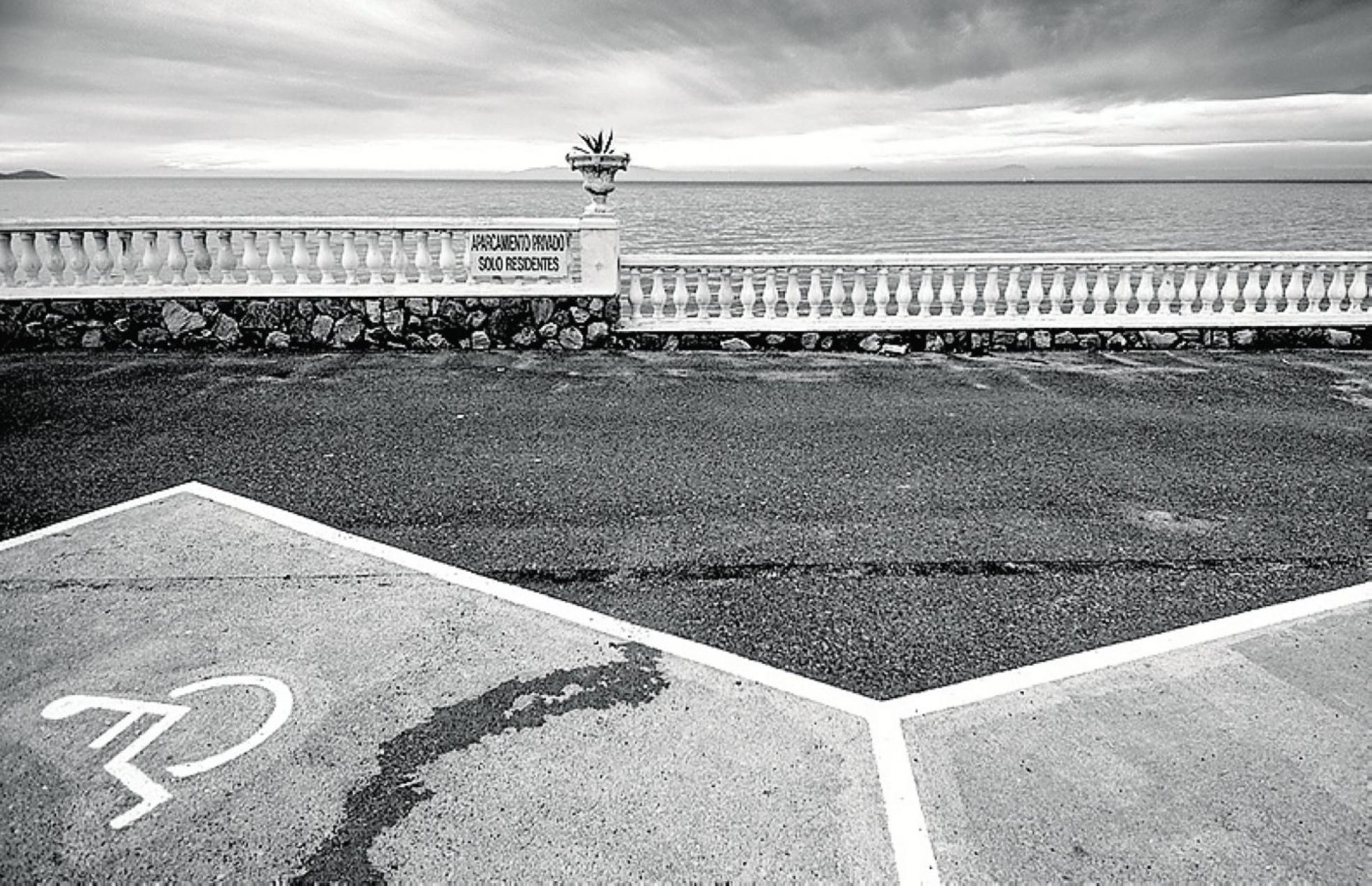 Estacionamientos en La Manga; tras la balaustrada, el Mar Menor. 