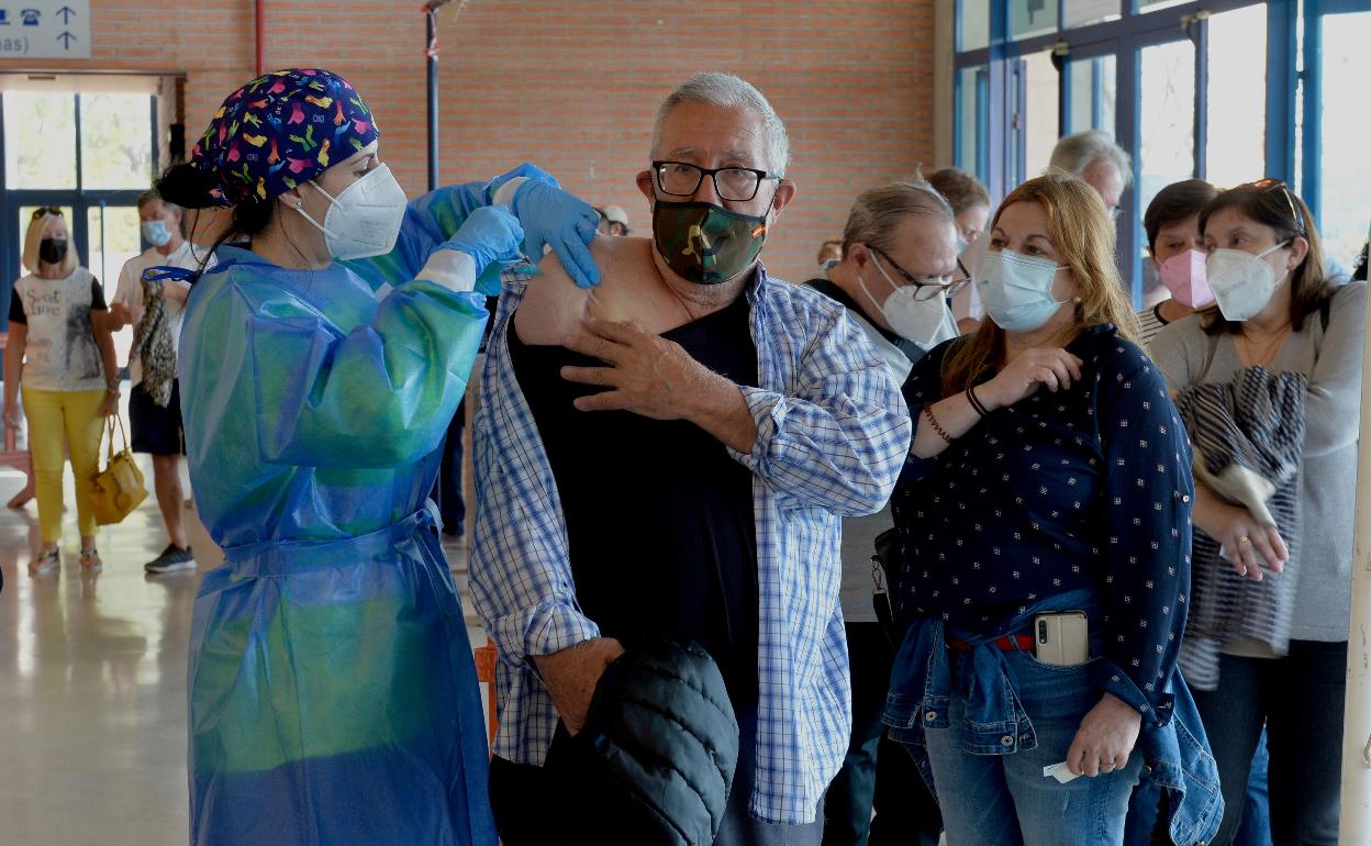 Una enfernera administra una dosis de la vacuna de AstraZeneca a un hombre en el Palacio de los Deportes de Murcia. 