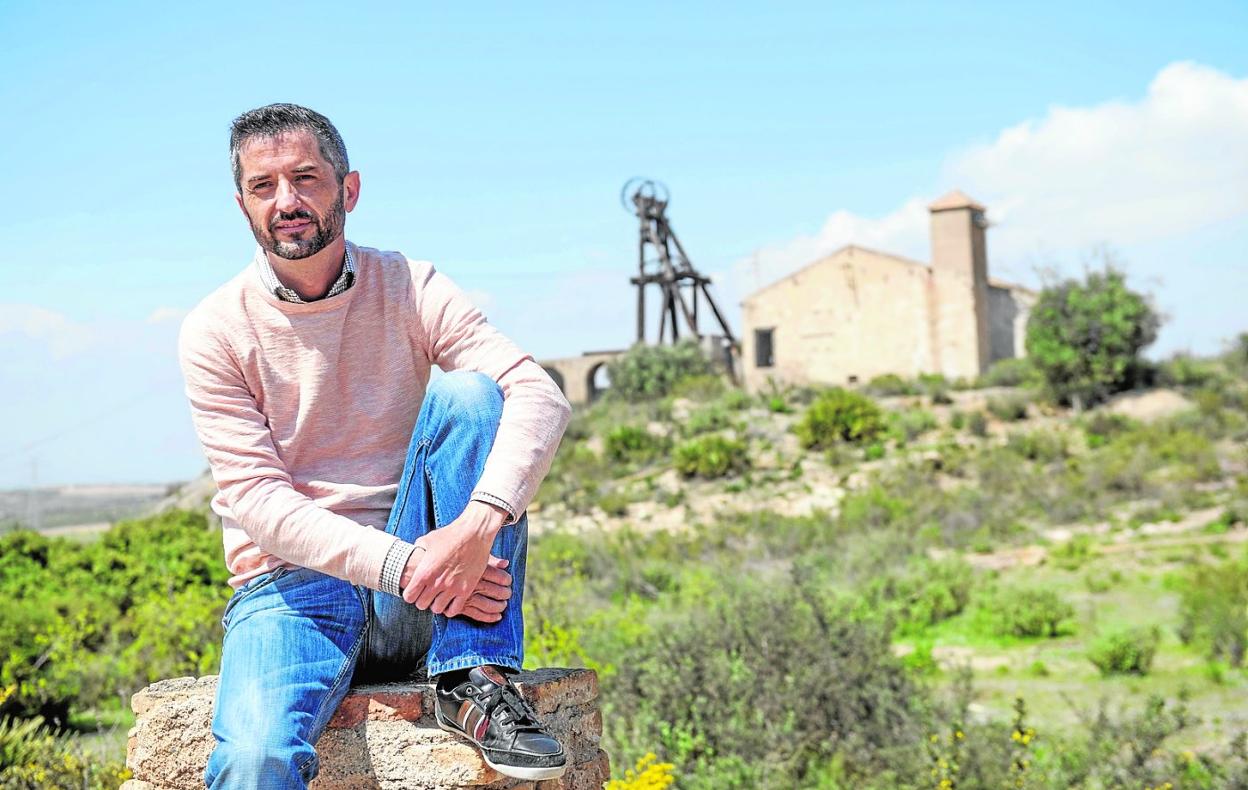 El pinatarense Nacho Sánchez Carrasco, fotografiado en la Sierra Minera, con un castillete al fondo. 