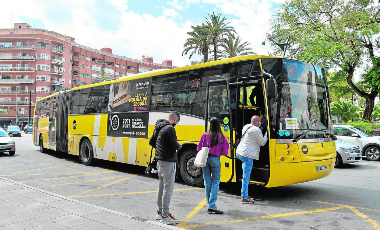 Viajeros hacen cola para subirse a un autobús interurbano en la plaza Circular de Murcia. 