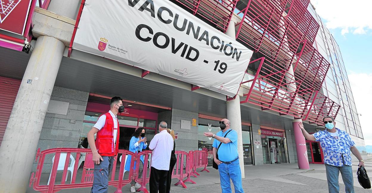 Vecinos de la capital citados ayer para vacunarse piden explicaciones al personal sanitario y los voluntarios de Cruz Roja, en el estadio Enrique Roca. 