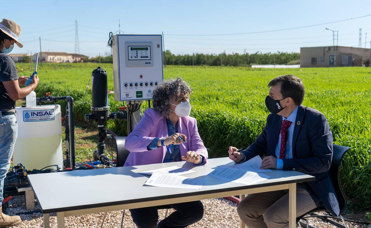 La rectora de la UPCT, Beatriz Miguel Hernández y el Director Técnico de Estrella Levante, Juan Antonio López Abadía, firmando el convenio. Detrás de ellos, un técnico del proyecto tomando muestras de salinidad.