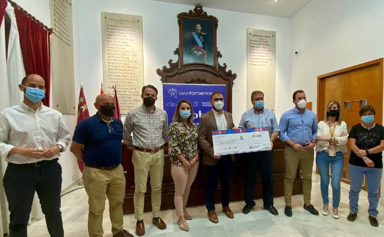 Entrega del cheque corre por Lorca a Cáritas.