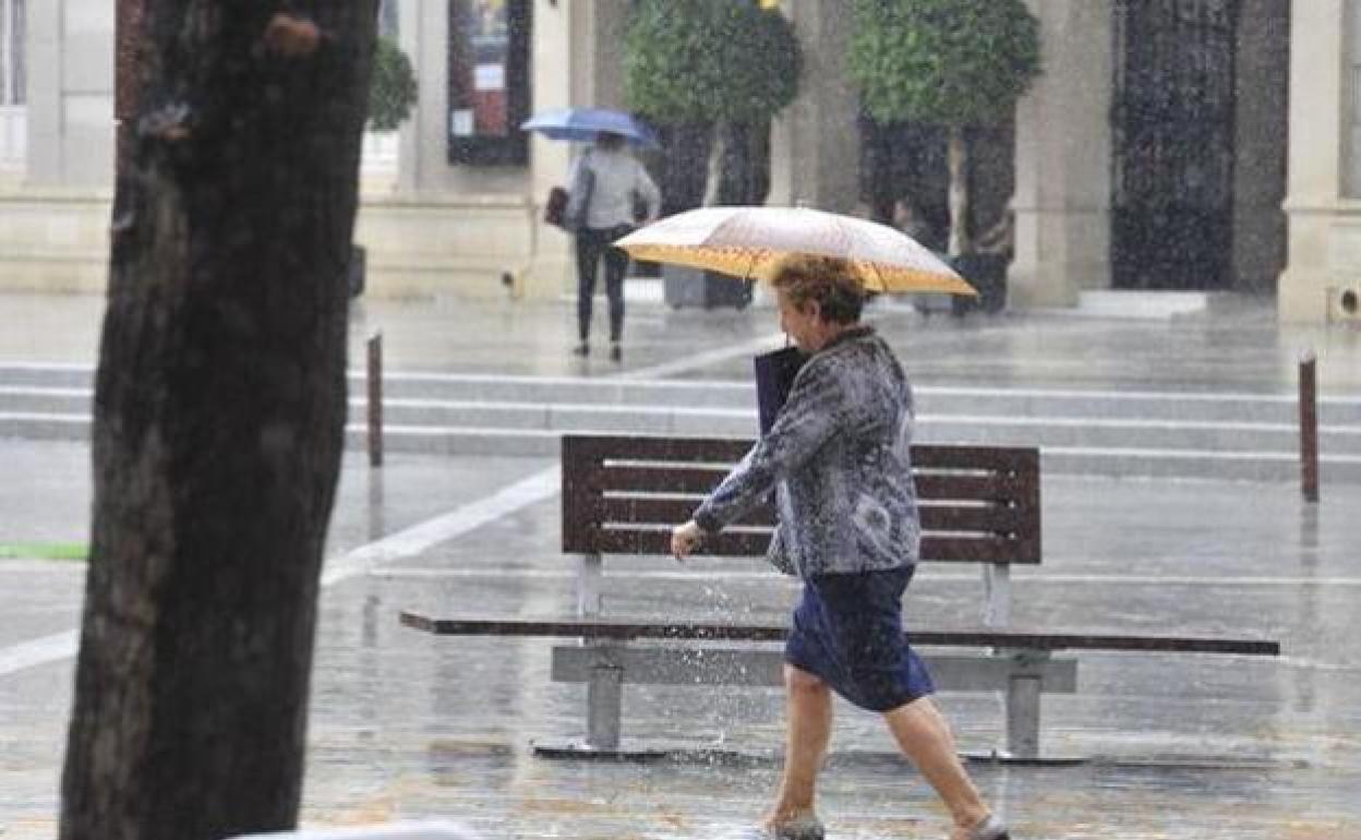 Una mujer camina bajo la lluvia en Murcia en una foto de archivo. 