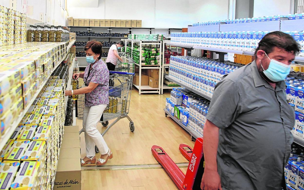 Voluntarios reponen los estantes en el centro de distribución de alimentos Galilea. 