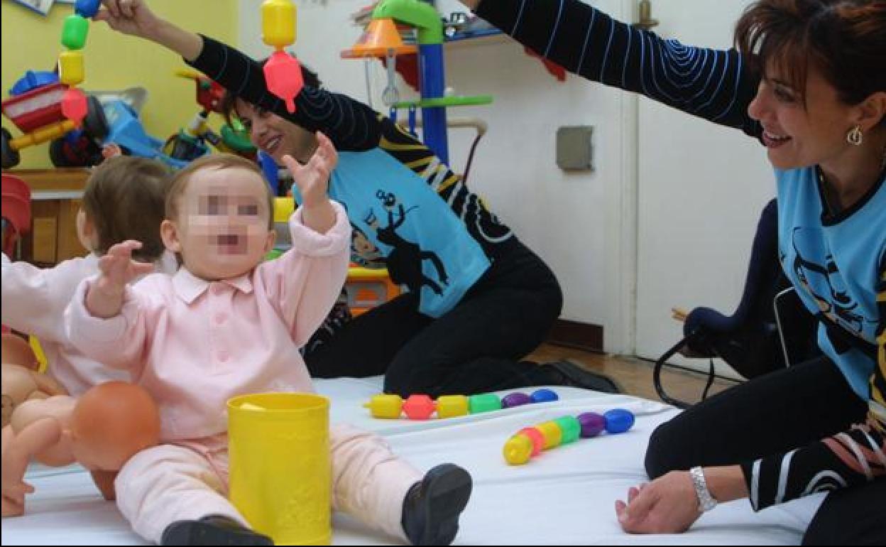 Una monitora atiende a un bebé en un centro de atención temprana, en una fotografía de archivo.