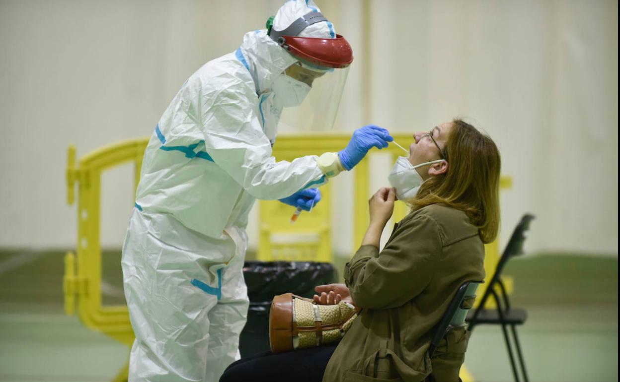 Un sanitario realiza una prueba PCR a una mujer, en una fotografía de archivo.