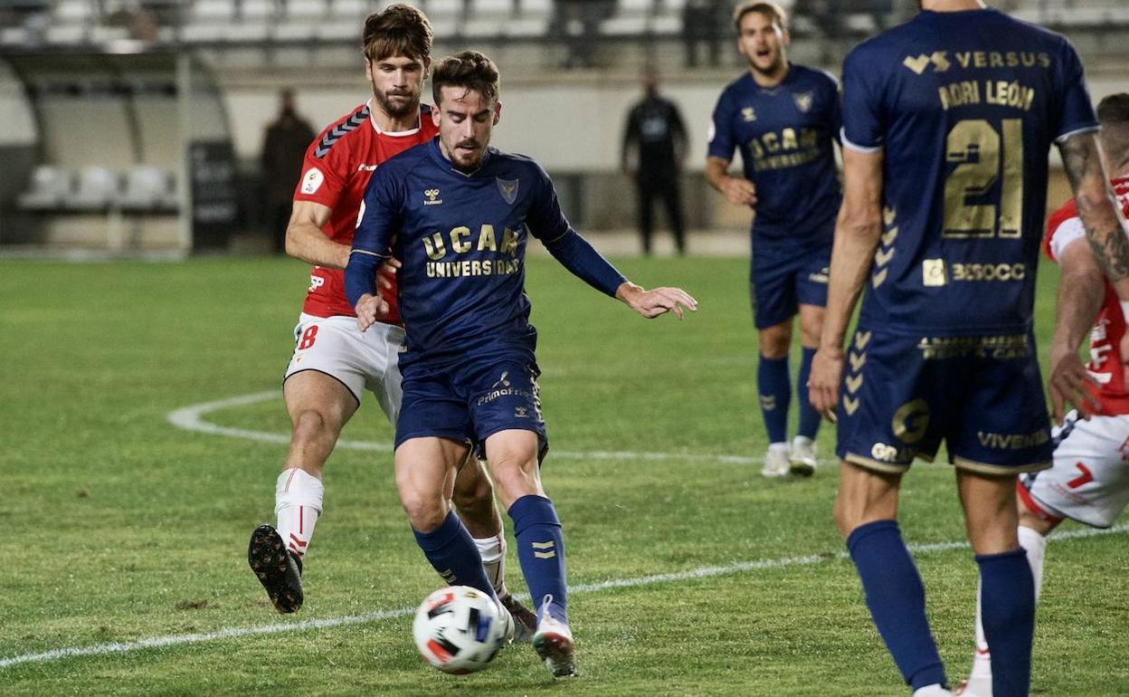 Mario Abenza, en el último choque entre Real Murcia y UCAM en el Enrique Roca, trata de robarle el balón a Rafa de Vicente.