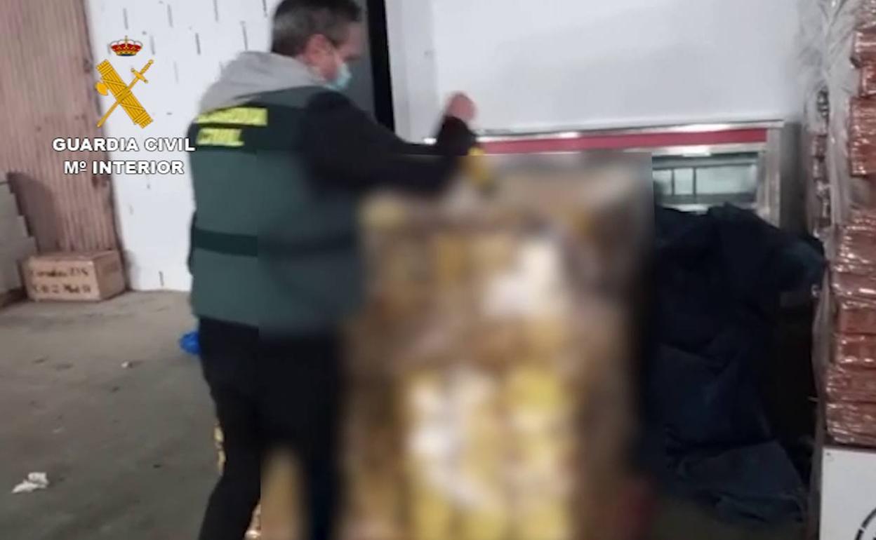 Un agente de la Guardia Civil, en el almacén donde acumulaban el whisky manipulado.