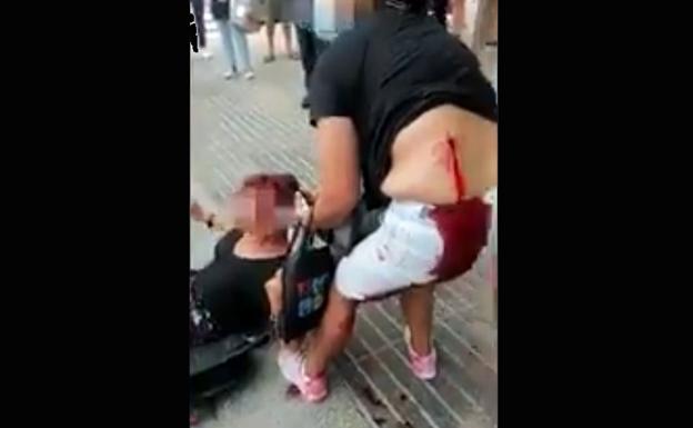 La víctima, con la herida abierta en la espalda, sujeta a su agresora. 