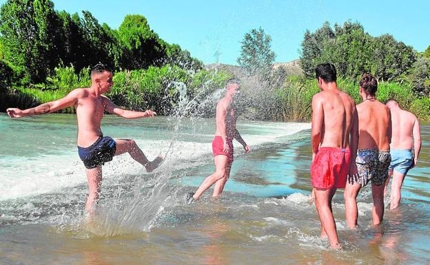 Jóvenes juegan en el agua, en la playa del Bayo (Calasparra).