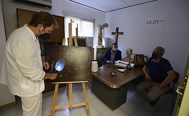 Mariano Cecilia Espinosa, codirector del CeartUM y profesor de Historia del Arte de la UMU, observa con luz ultravioleta una obra flamenca para conocer cuáles son las partes originales y cuáles repintadas. 
