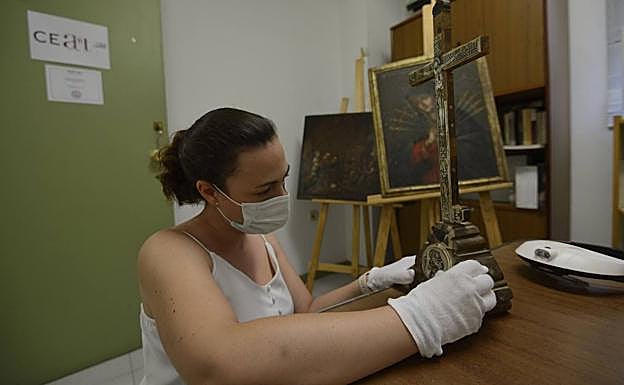 Gema Ruiz observa y analiza la iconografía de una cruz de Jerusalén del s. XVIII de nácar y madera. 