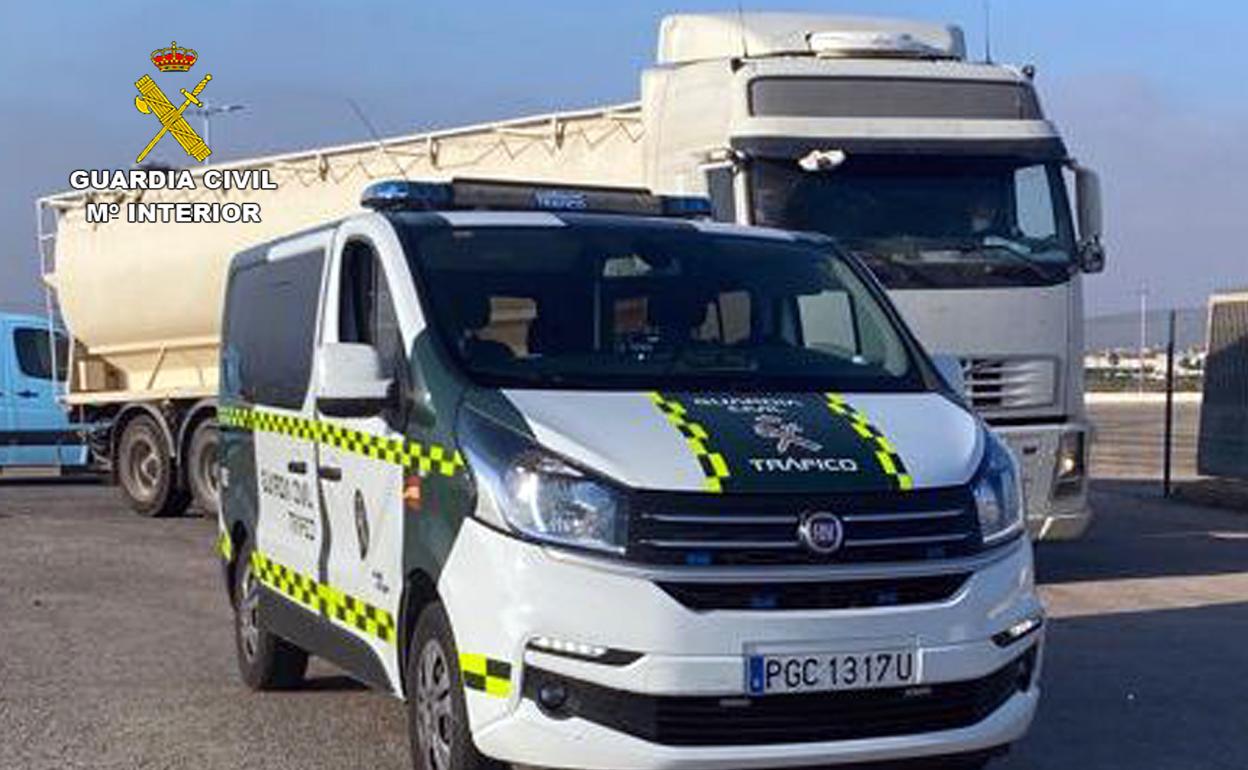 Un vehículo de la Guardia Civil junto al camión inmovilizado.