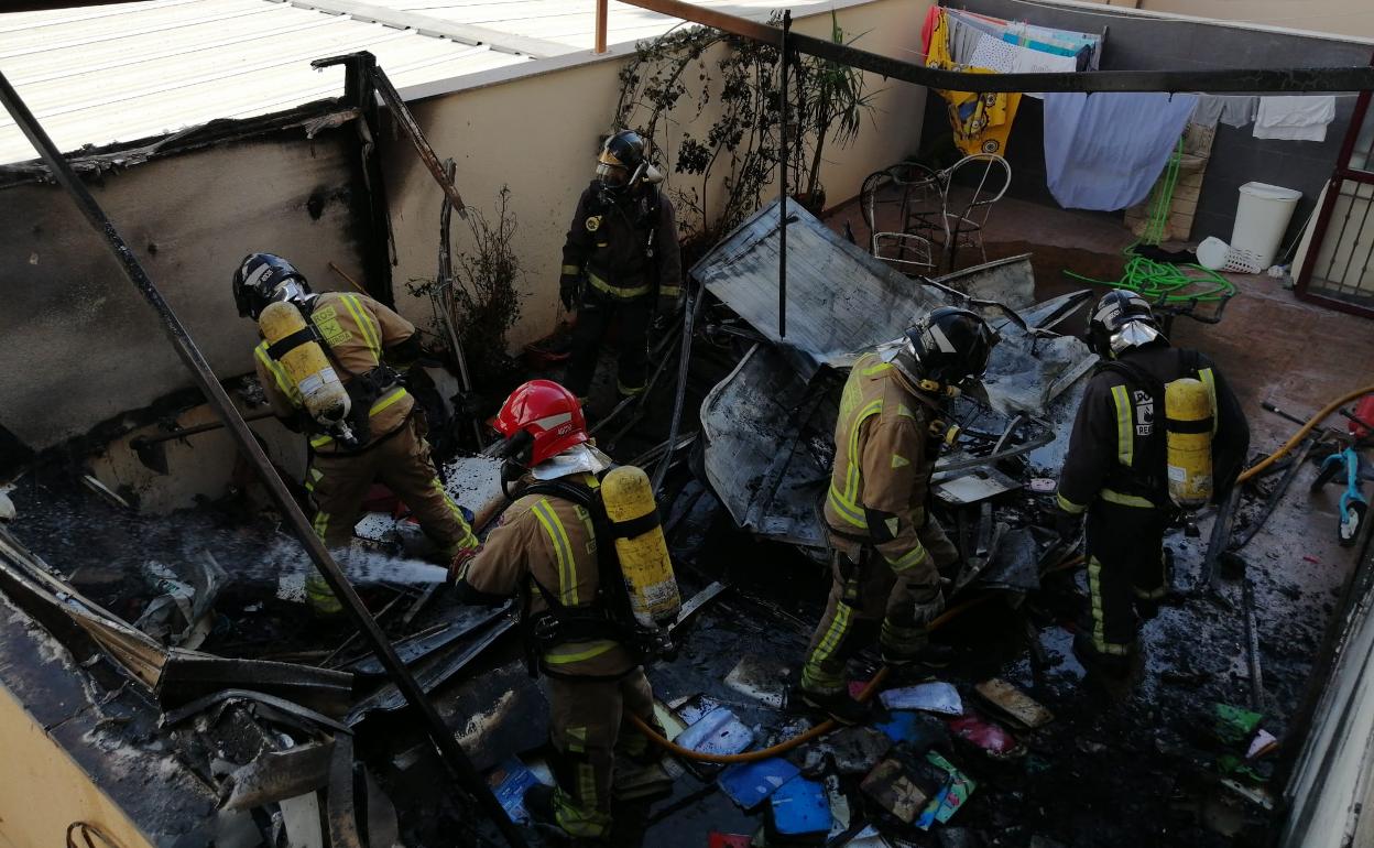 Bomberos en el patio interior incendiado este jueves.