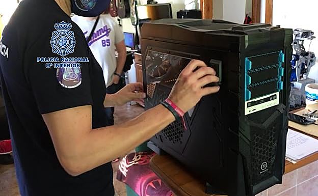 Un agente, con uno de los ordenadores incautados en la operación. 