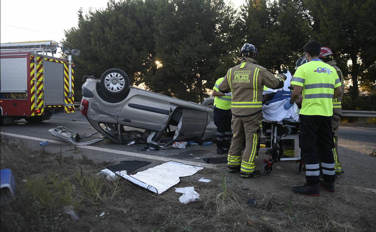 Bomberos y sanitarios atienden al herido en un accidente de tráfico en la AP-7, en San Javier.