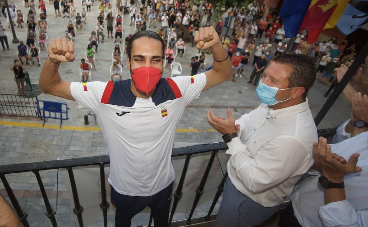 Katir levanta los brazos en el balcón del Ayuntamiento de Mula; a la derecha, el alcalde Juan Jesús Moreno.