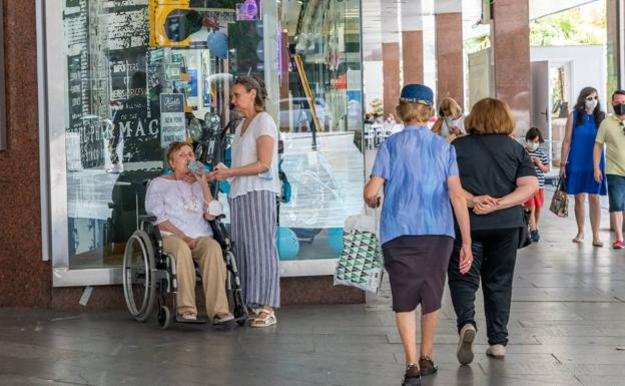 Mujeres hidratándose y resguarándose a la sombra durante un día de calor en Murcia. 