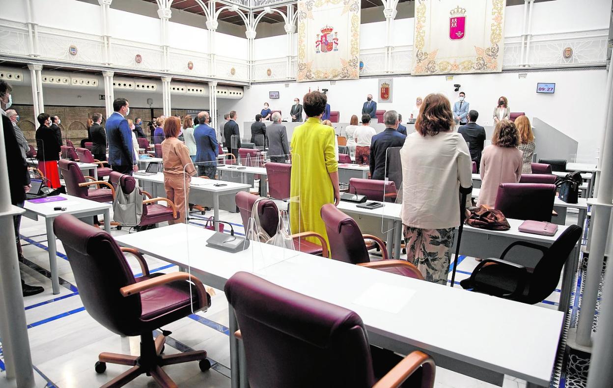 Diputados de la Asamblea Regional guardan un minuto de silencio por las víctimas de la Covid antes del inicio de un Pleno. 