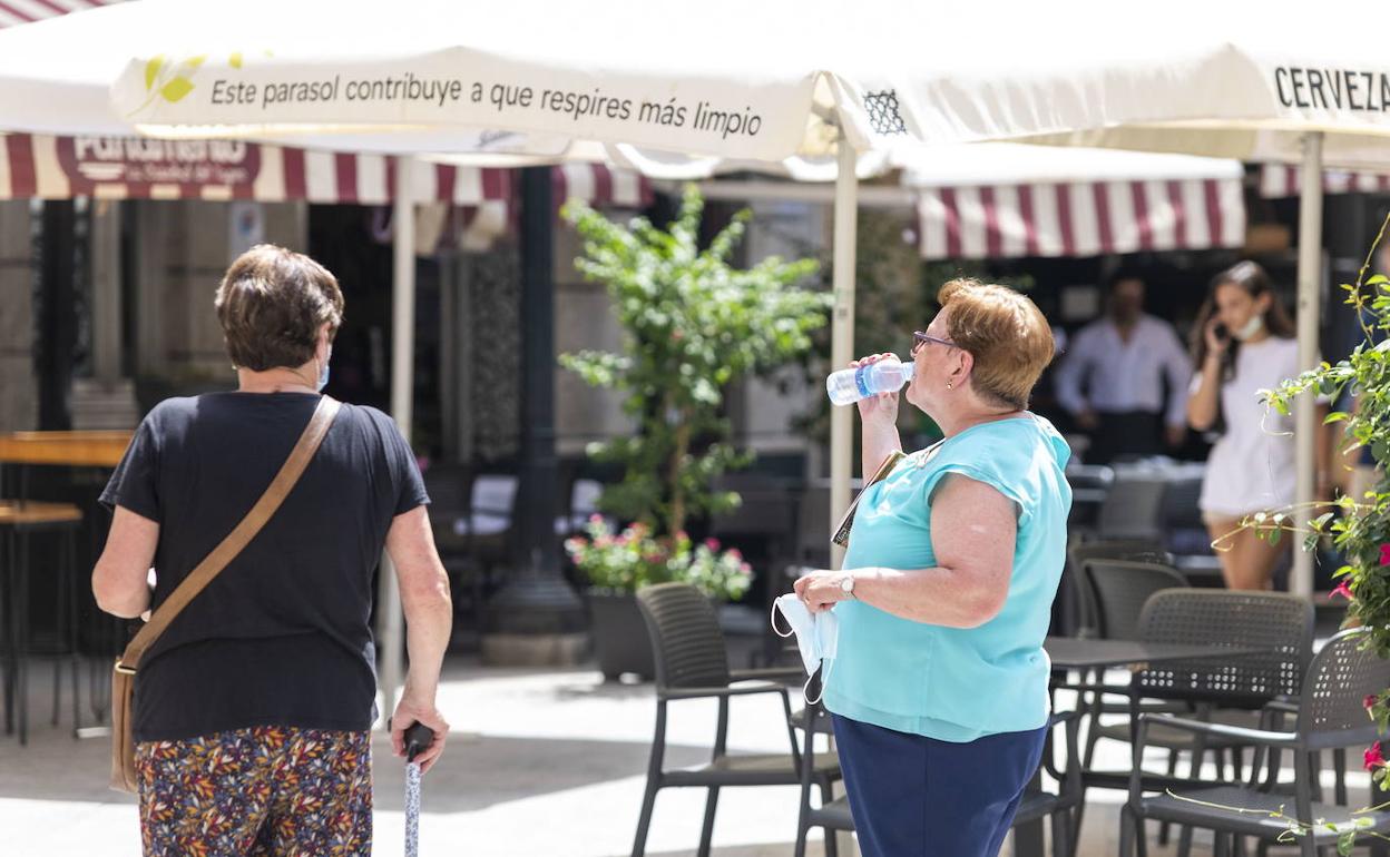 Una mujer bebiendo agua en una plaza del centro de Murcia, en una imagen de este domingo. 