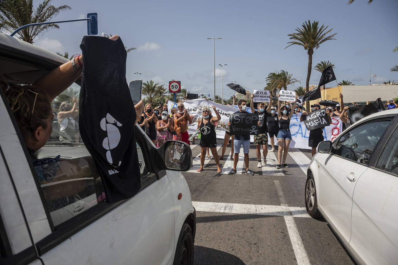 Fotos: Colectivos vecinales y ecologistas protestan en defensa del Mar Menor al paso de La Vuelta