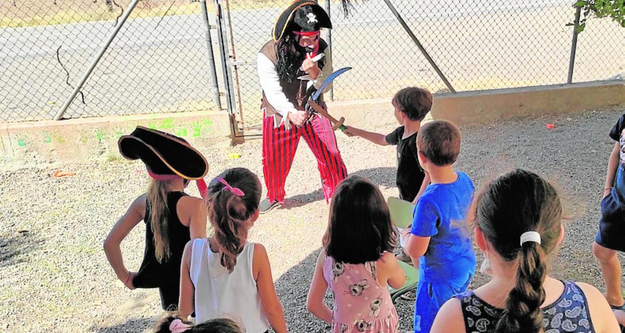 Varios alumnos juegan con un monitor en la escuela de verano, ayer. 