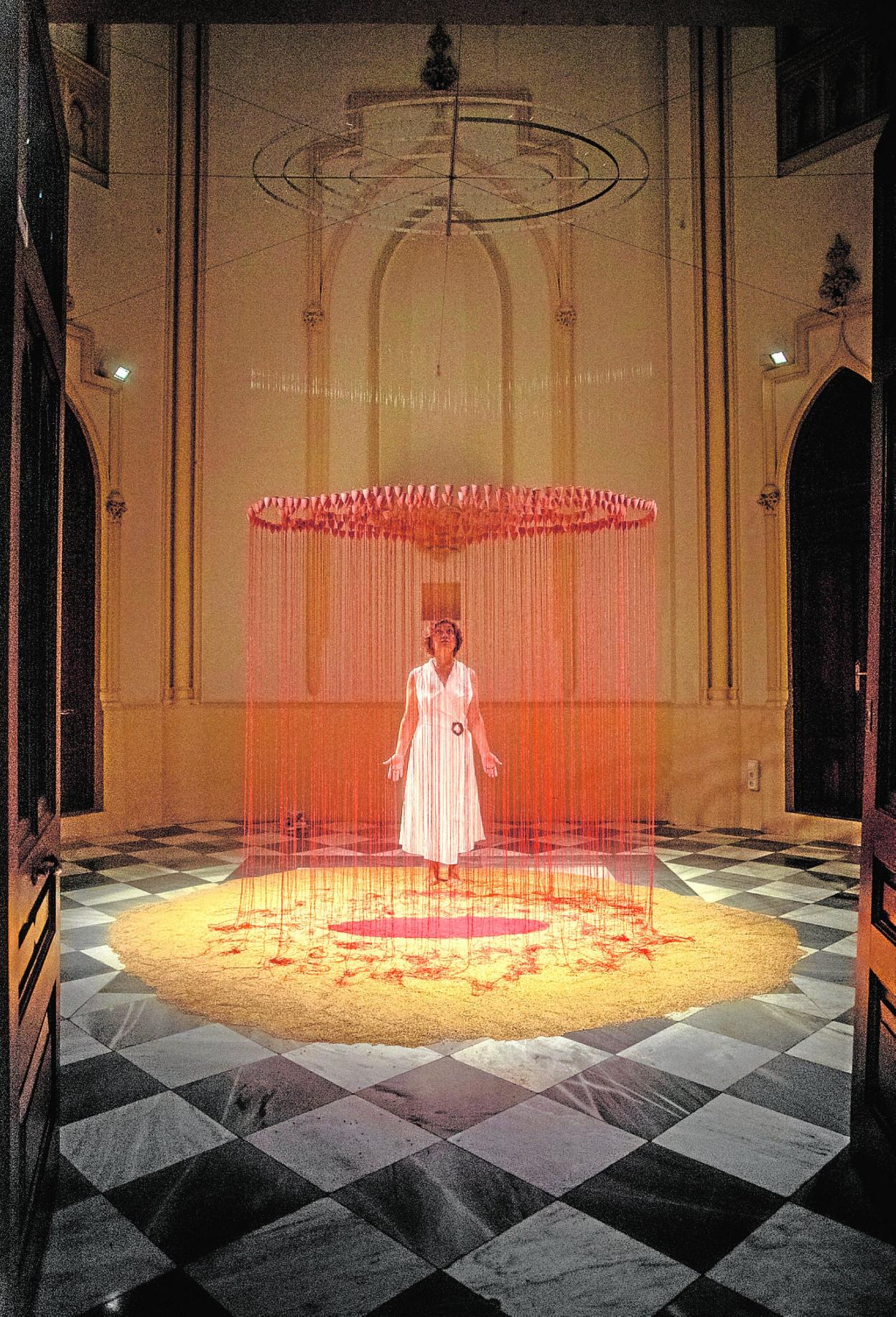 Concha M. Montalvo junto a su obra 'Lluvia roja', en la Sala La Capilla de la UMU, en Murcia. 