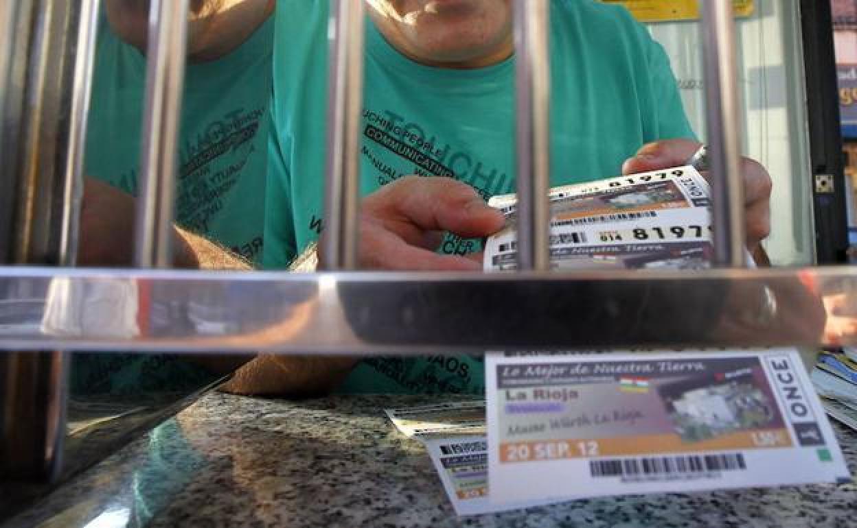 Un vendedor de la ONCE ofrece un cupón en su punto de venta en una foto de archivo.