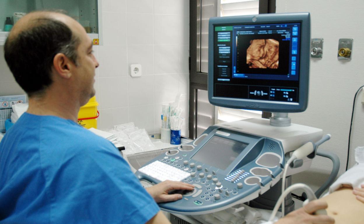 Un sanirtario hace una ecografía a una embarazada en una imagen de archivo. 