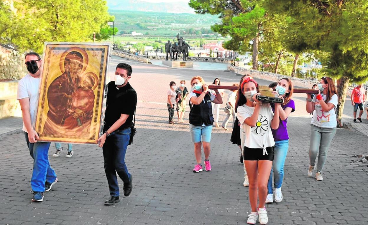 Varios jóvenes portan la Cruz Peregrina y el icono de la Virgen, a su llegada a la basílica, ayer. 