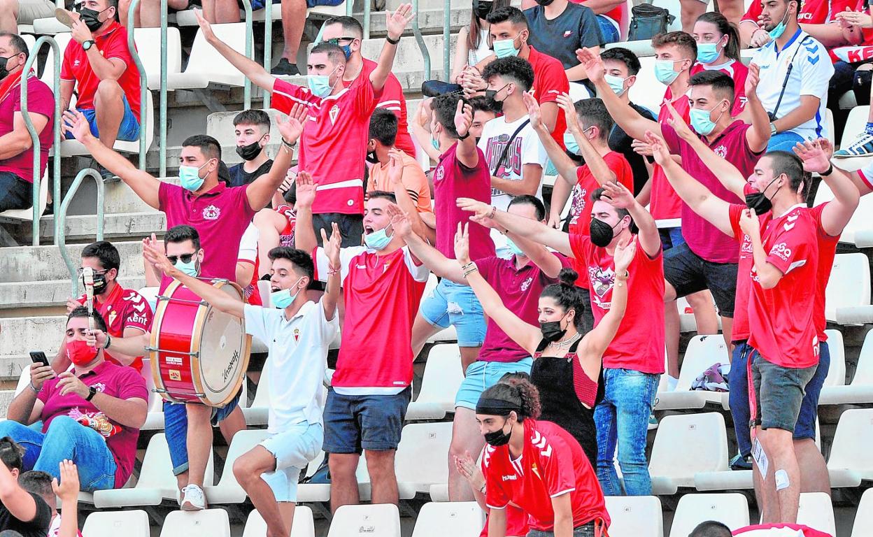 Aficionados del Real Murcia celebran en el estadio Enrique Roca un gol de su equipo ante el Intercity, el domingo. 