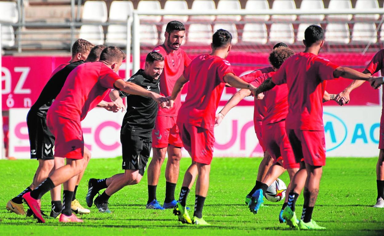 Mario Simón, en el centro, junto a algunos futbolistas de su plantilla en un entrenamiento en el Enrique Roca. 