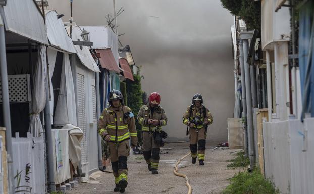 Bomberos trabajando en el incendio del camping Caravaning de La Manga.