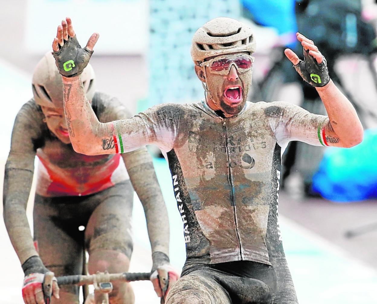 El italiano Sonny Colbrelli, cubierto de barro, alza los brazos tras imponerse ayer en la meta de Roubaix. 