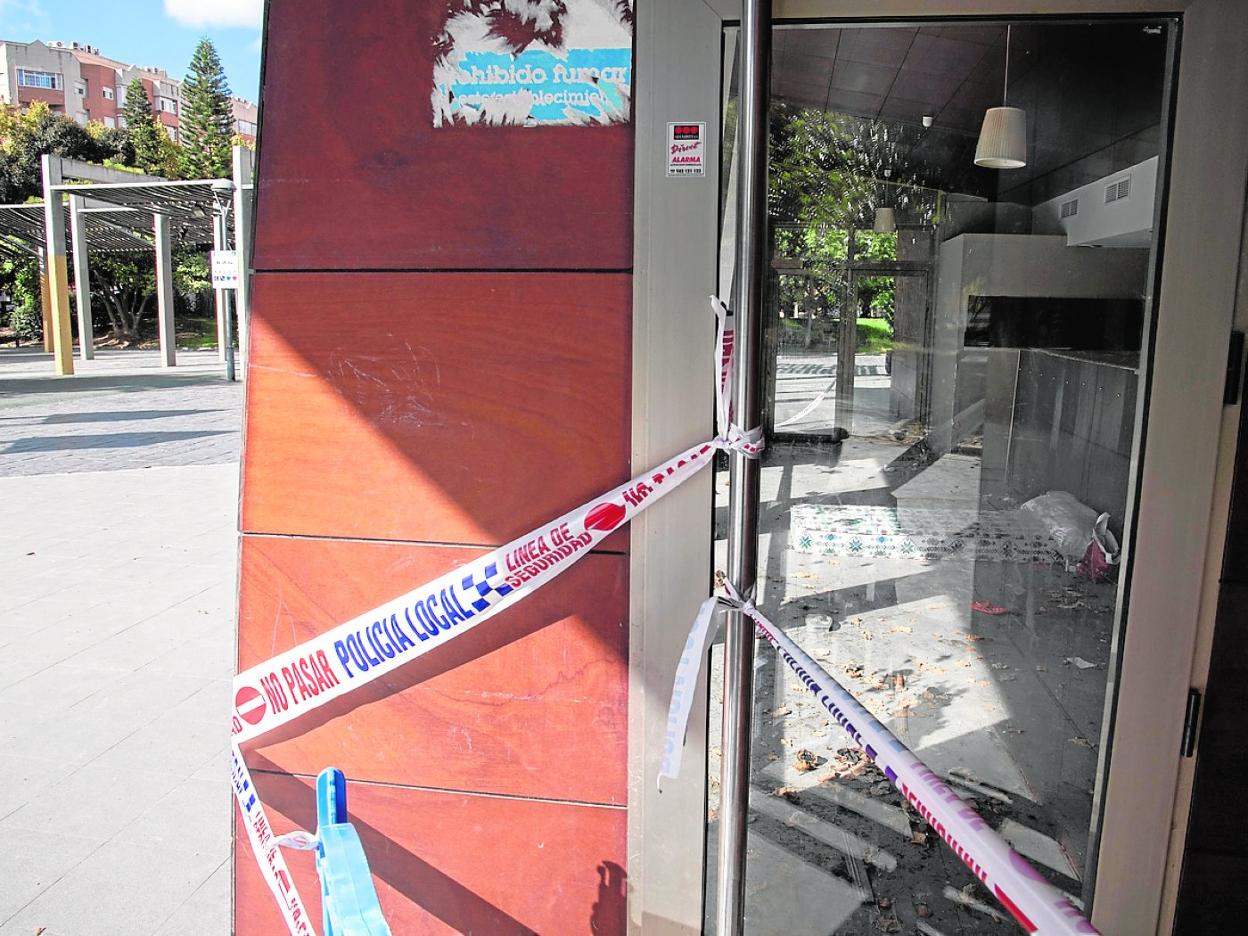 Cintas de la Policía en la puerta del quiosco cerrado; dentro, un colchón entre basura. 