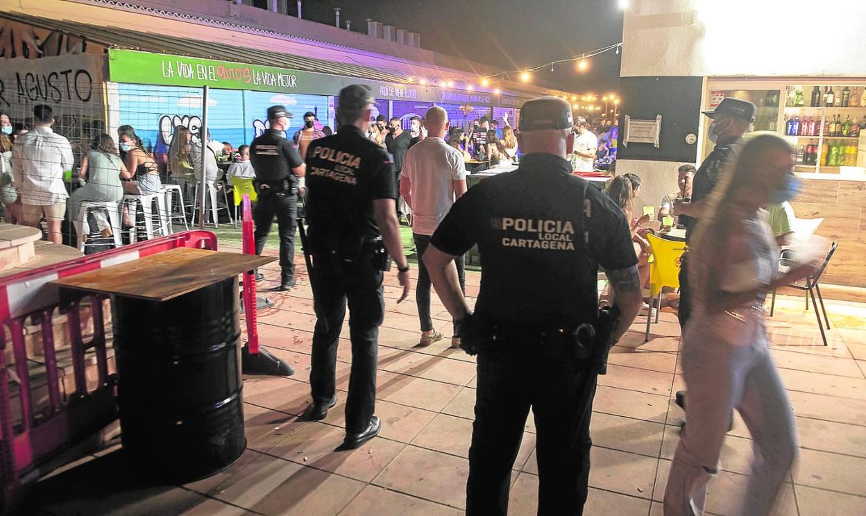 Cuatro agentes de la Policía Local, durante un control para evitar botellones en Cabo de Palos, en julio. 