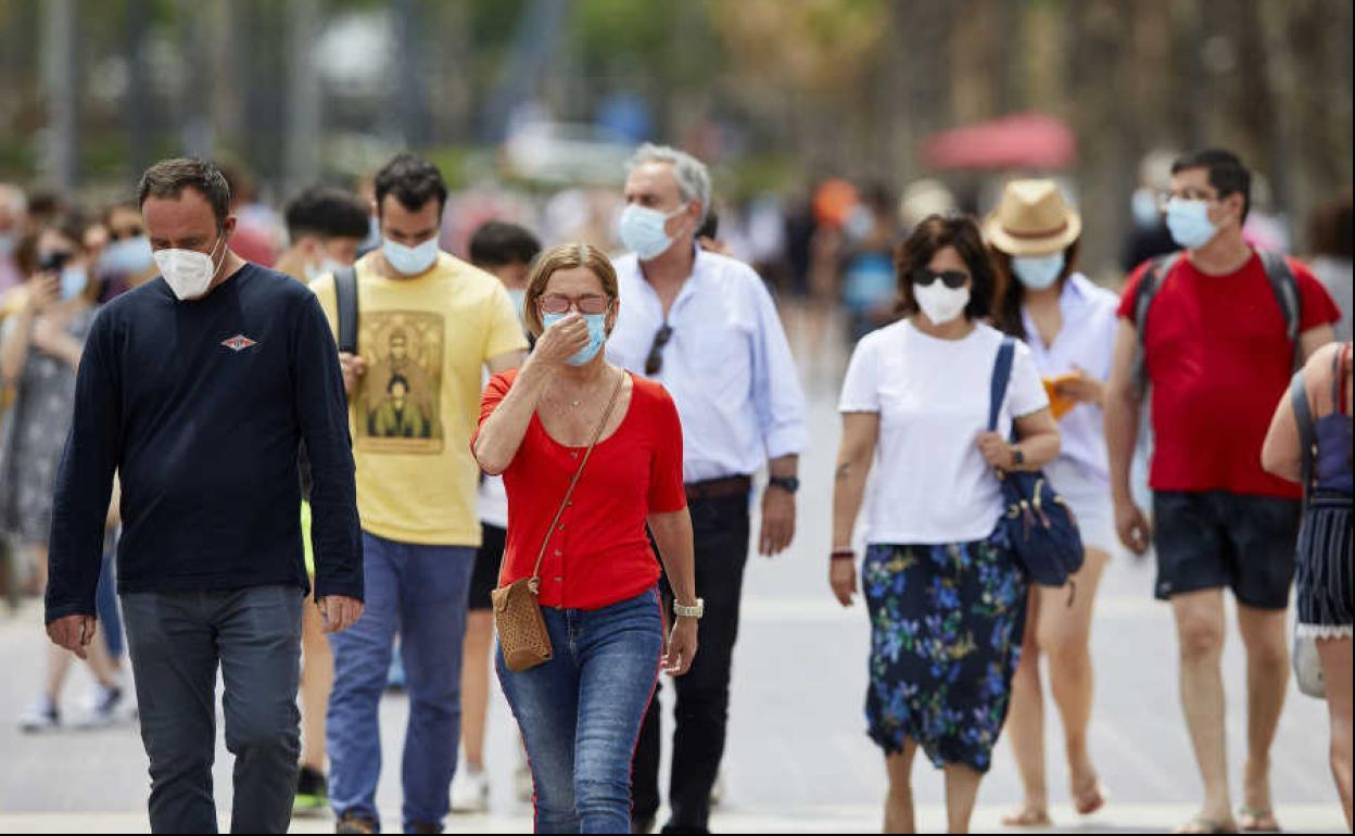 Varias personas pasean por la calle. 