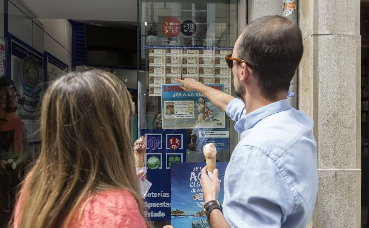 Dos personas eligiendo un décimo de la Lotería de Navidad, en una imagen de archivo.