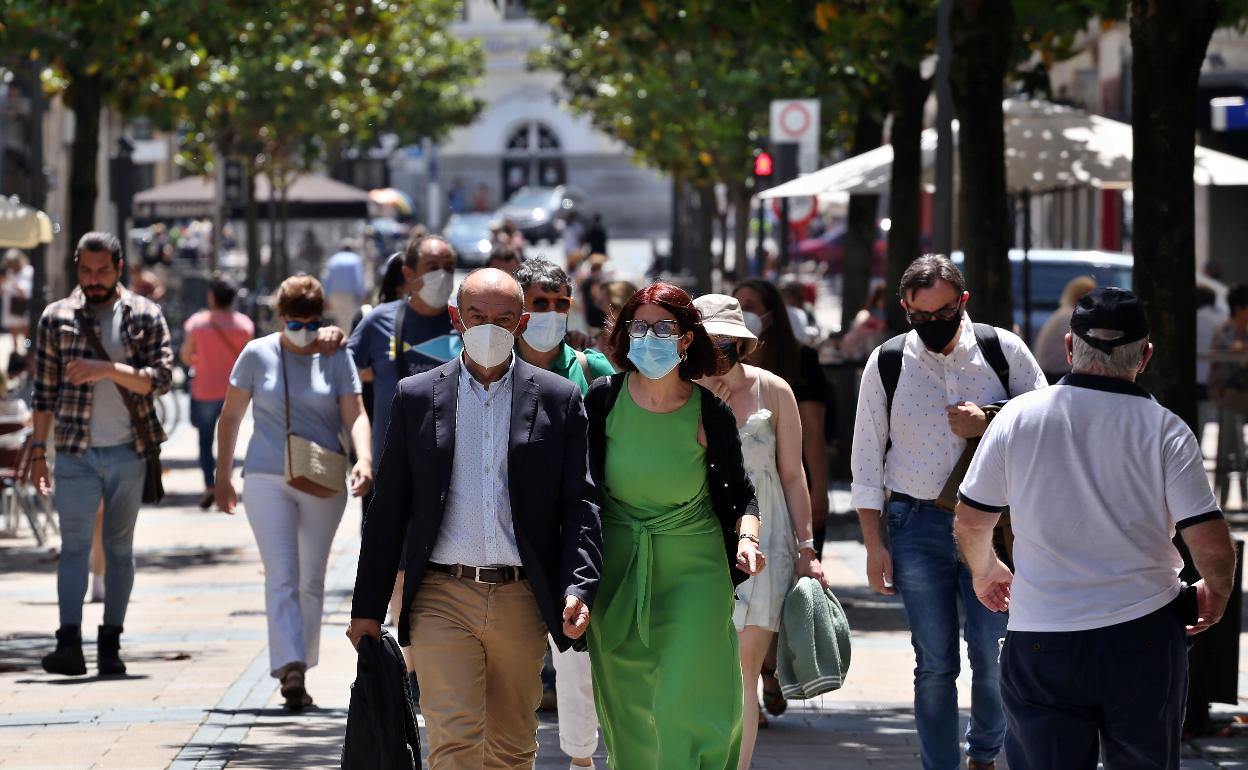 Peatones con mascarillas en la calle.