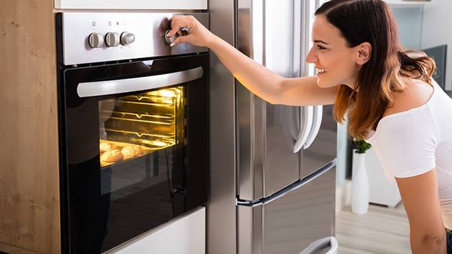 Una chica programando un horno.