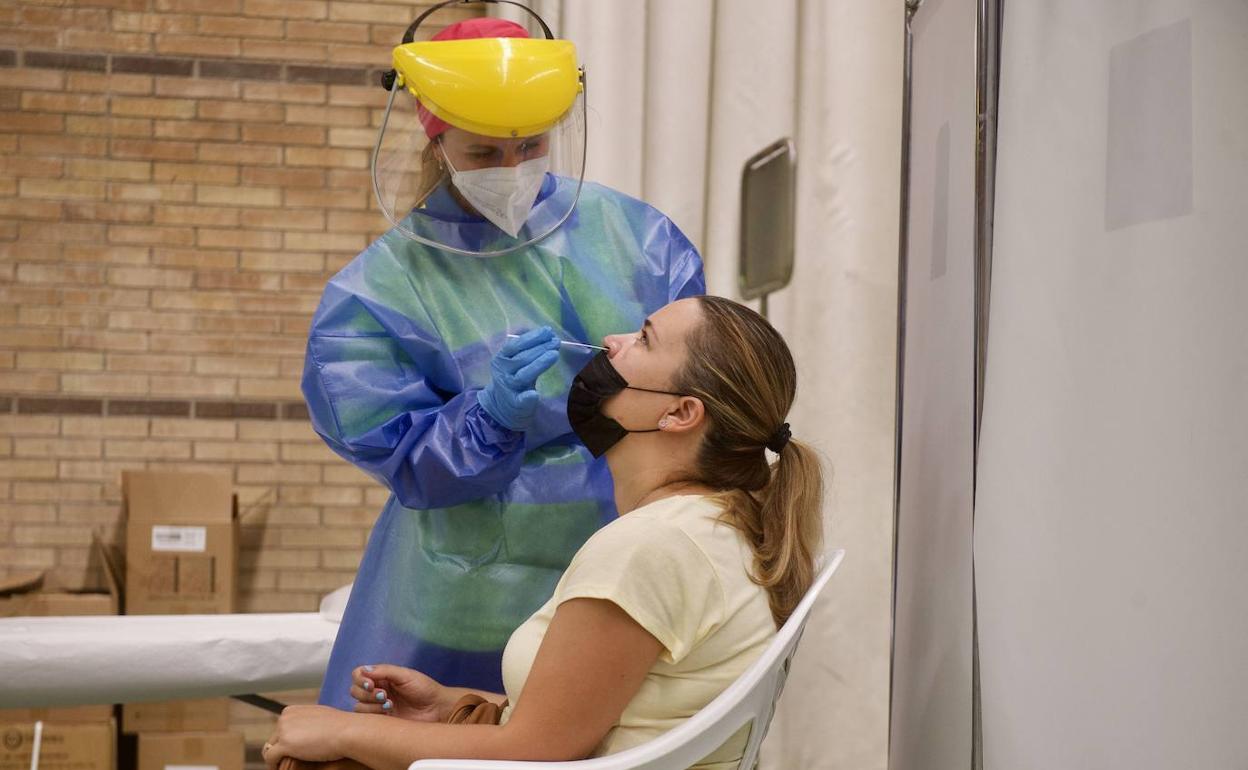 Un sanitario realiza una prueba PCR a una paciente, en una fotografía de archivo.