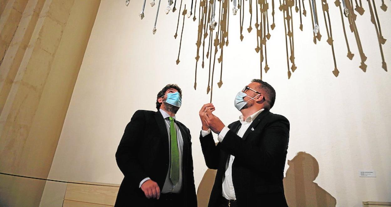 El presidente López Miras y el comisario Juan Francisco Rueda observan la obra 'Gloria', de Cristóbal Hernández Barbero, en la Iglesia de San Esteban, sede de la muestra 'Mapa. Territorio. Región'. 