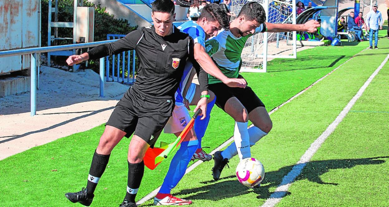 Dos jugadores pugnan por el balón en el Lorca FC-Roldán. 