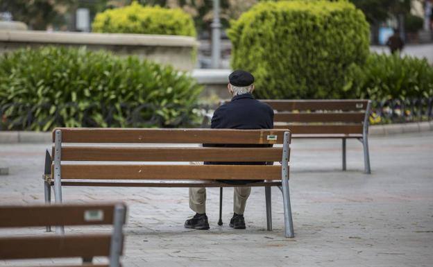 Un anciano sentado en un parque. 