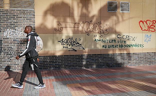 Un hombre pasea por la calle Pedro Martín Zermeño, donde hay una pintada ensalzando la figura del dictador Adolf Hitler.