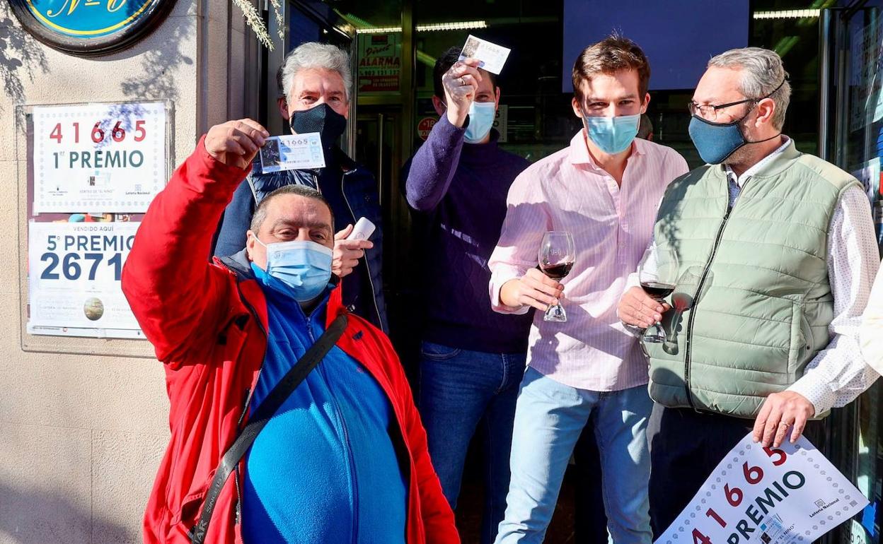 Uno de los agraciados, muestra el décimo ganador junto a los trabajadores de la Administración de Lotería número 6 de Logroño.