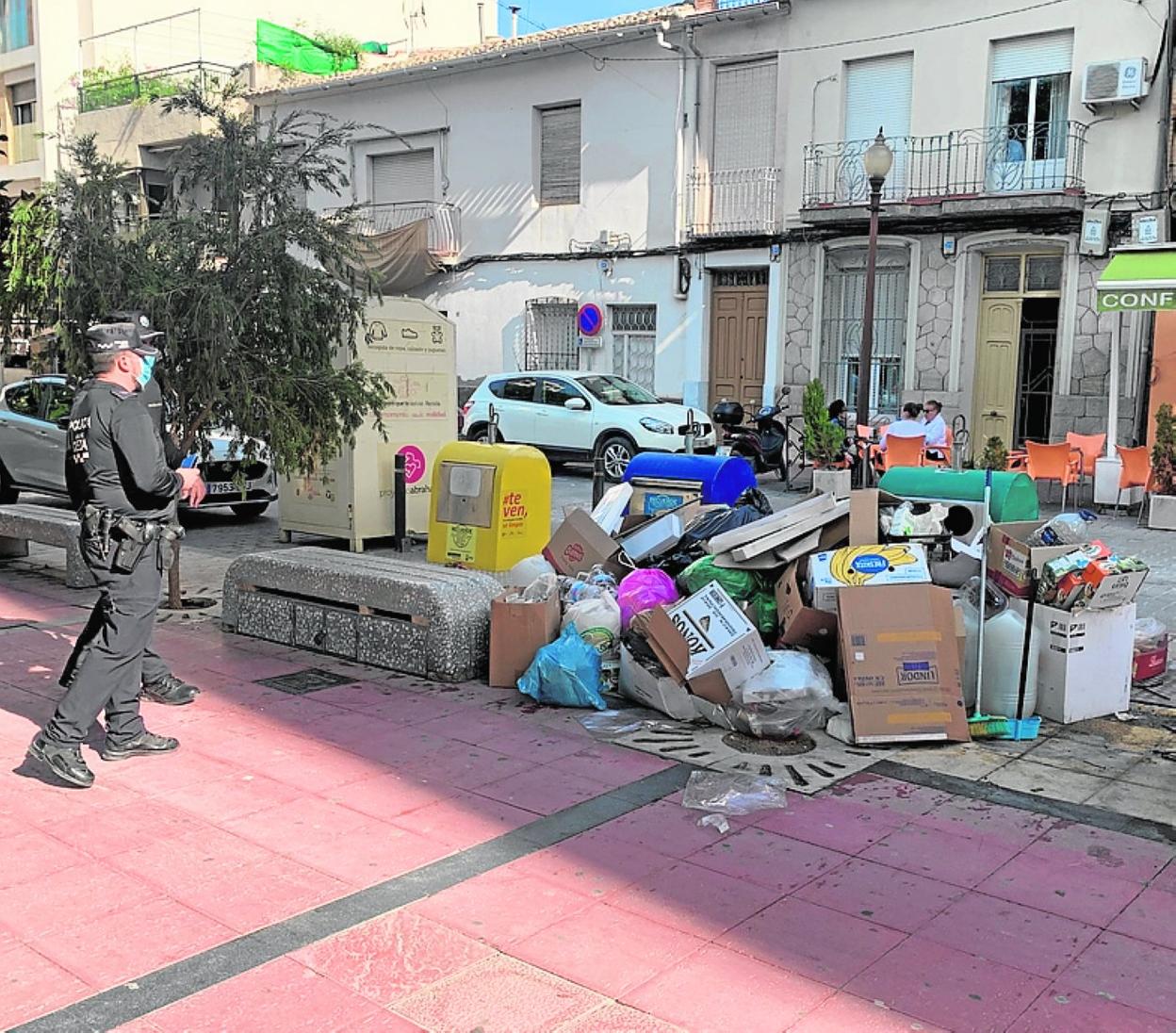 Dos agentes observan la basura en el suelo en la plaza de España. 