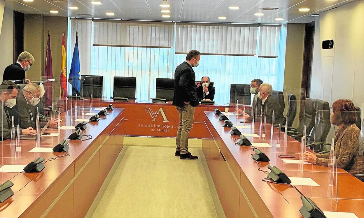 Joaquín Segado, del PP, de pie, habla con los socialistas Francisco Lucas y Alfonso Martínez Baños antes del inicio de la Junta de Portavoces de ayer en la Cámara autonómica. 