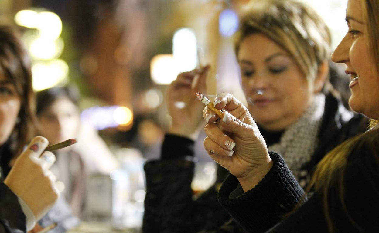 Varias mujeres fuman en un bar. 